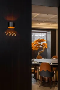 Modern restaurant interior with wooden elements and orange accents.