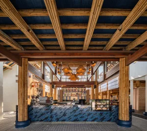 Modern coffee shop interior featuring a wooden bar and blue tiled flooring.