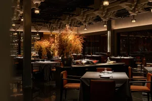 Modern restaurant interior with metal, wood, and glass materials.