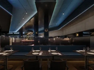 Modern, industrial restaurant interior with exposed metal ceiling, concrete walls, and glass partitions.