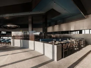 A modern restaurant interior featuring concrete and glass materials.