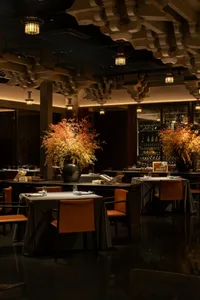 A modern restaurant interior with concrete, glass, and minimalist design elements.