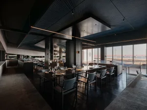 A modern restaurant interior with dark wood, glass, and metal elements