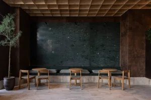 A modern restaurant interior with stone seating area and minimalist design.