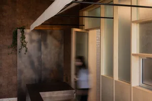 Modern office interior with minimalist design featuring concrete, glass, and wood elements.