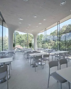 Modern cafeteria room with white tables and chairs, large windows, and natural light.