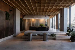 Modern hotel lobby with minimalist design and concrete materials.