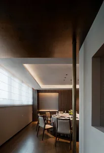 Modern restaurant interior with sleek, minimalist design features, including wooden paneling, leather seating, and glass elem