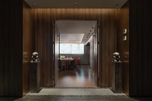Modern restaurant interior with wooden walls and a dining area.