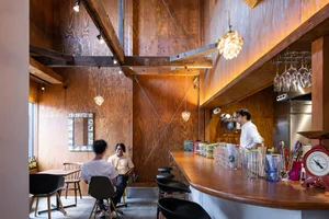 Interior view of an industrial-themed restaurant featuring wooden walls and furniture.