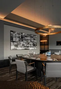 Modern dining room featuring a circular table with black wooden chairs, wall art, and indoor lighting.