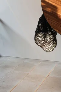 Circular shadow of textile lampshade hanging from wooden surface