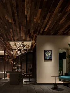 A cozy residential entrance featuring wooden walls and ceiling, with a hanging light fixture and a framed artwork on the wall