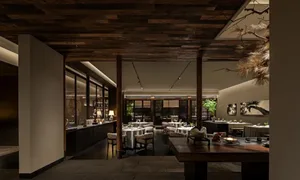 Modern restaurant interior with wooden tables, glass windows, and stone accents