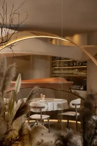 Interior of a modern restaurant with casual dining setup featuring soft textiles and leather