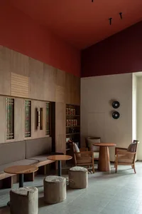 Modern restaurant interior with wooden furniture, leather seats, and concrete flooring.