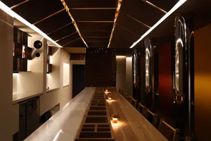 Wooden counter in a modern restaurant interior with illuminated elements and a sleek design.