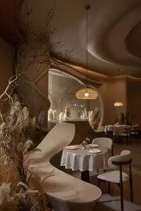 Modern interior design of a restaurant featuring neutral-toned materials and a sophisticated, minimalist decor.