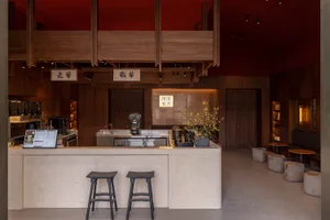 A modern coffee shop interior featuring a stylish, minimalist bar counter made of natural stone with a warm lighting setup an