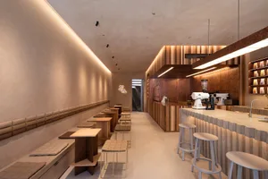 Modern coffee shop featuring wooden seating, concrete flooring, and metal counter