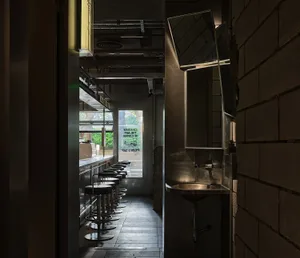 Industrial-style restaurant interior with metal stools and concrete walls