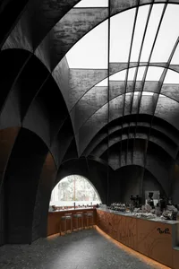 Industrial-style coffee bar with concrete materials and a large window.