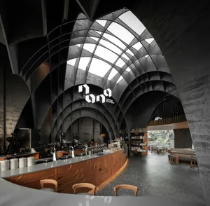 A modern, industrial-style coffee shop with concrete and metal finishes.