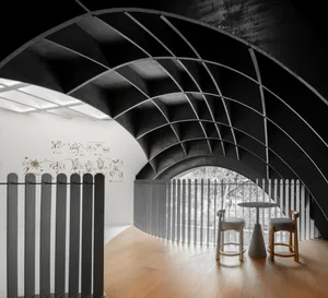 A minimalist cafe interior featuring hardwood floors, metal railings, and large windows allowing natural light.
