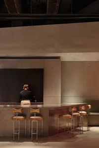 Modern industrial coffee shop interior featuring a sleek concrete counter and minimalist design.