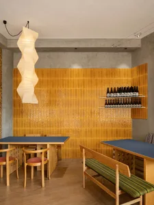 Modern restaurant interior design featuring warm colors and wooden furniture.