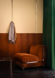 A cozy, amber-colored velvet armchair in a stylish living room setting.