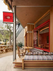 A restaurant exterior featuring industrial design elements with warm materials like wood, metal, and fabric.