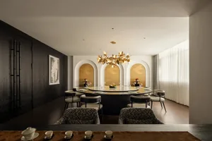 A modern restaurant featuring metal, glass, marble, and wood materials.