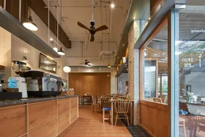 A cozy coffee shop interior with wooden furnishings, glass windows, and metal details.