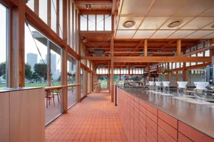 Interior of an industrial-style coffee shop with brick counter and open-air seating area.