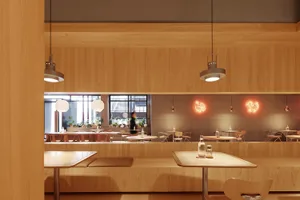 A modern coffee shop interior with wooden elements and hanging lamps.