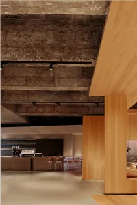 Photo of a modern restaurant interior with concrete walls and a minimalist design.
