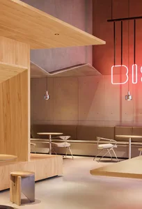 Modern restaurant interior with wooden tables, chairs, and benches.
