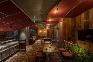 An industrial-style restaurant interior featuring wood, stone, and metal elements.