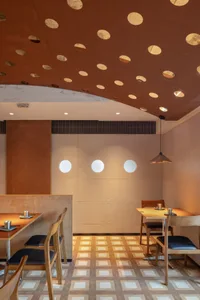 Modern industrial restaurant interior with wood tables, metal accents, and patterned floor.
