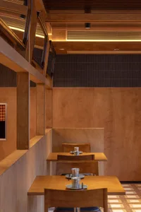A modern restaurant interior featuring wooden panels and seating