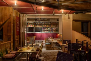 Modern industrial-style cafe bar with wooden furniture and concrete floor