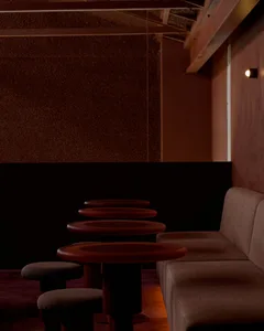 Contemporary coffee shop interior featuring red lighting and fabric seating.