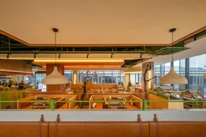 A modern cafe bar interior with wooden booths, metal pendant lights, and glass walls.