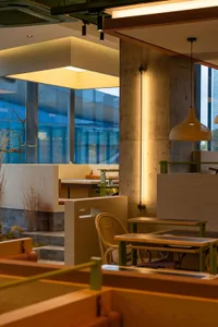 Modern cafeteria with concrete walls and contemporary seating arrangements.