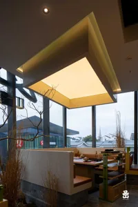 Modern restaurant interior featuring a contemporary design with concrete walls and seating.