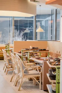 A modern restaurant interior designed with a combination of wooden and glass materials, featuring clean lines and natural lig