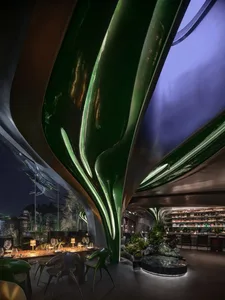 A modern restaurant featuring green leaf-shaped columns and metallic elements.