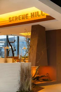 Luxury restaurant interior with concrete, wood, and plant accents.