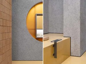 A minimalist interior space with a terrazzo floor and wall paneling.